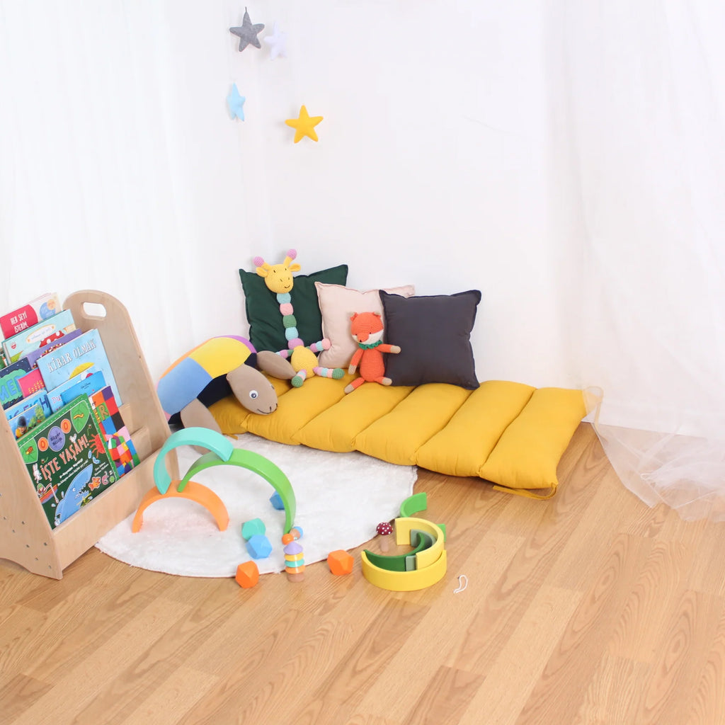 a child's play room with a yellow sofa and toys
