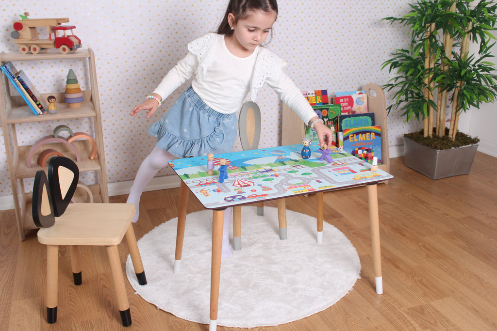 a little girl playing with a table and chairs