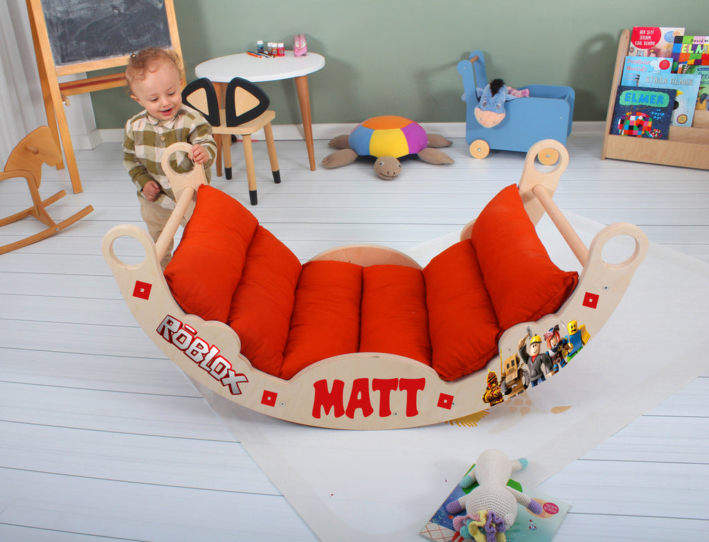a toddler plays in a toy sleigh in a play room