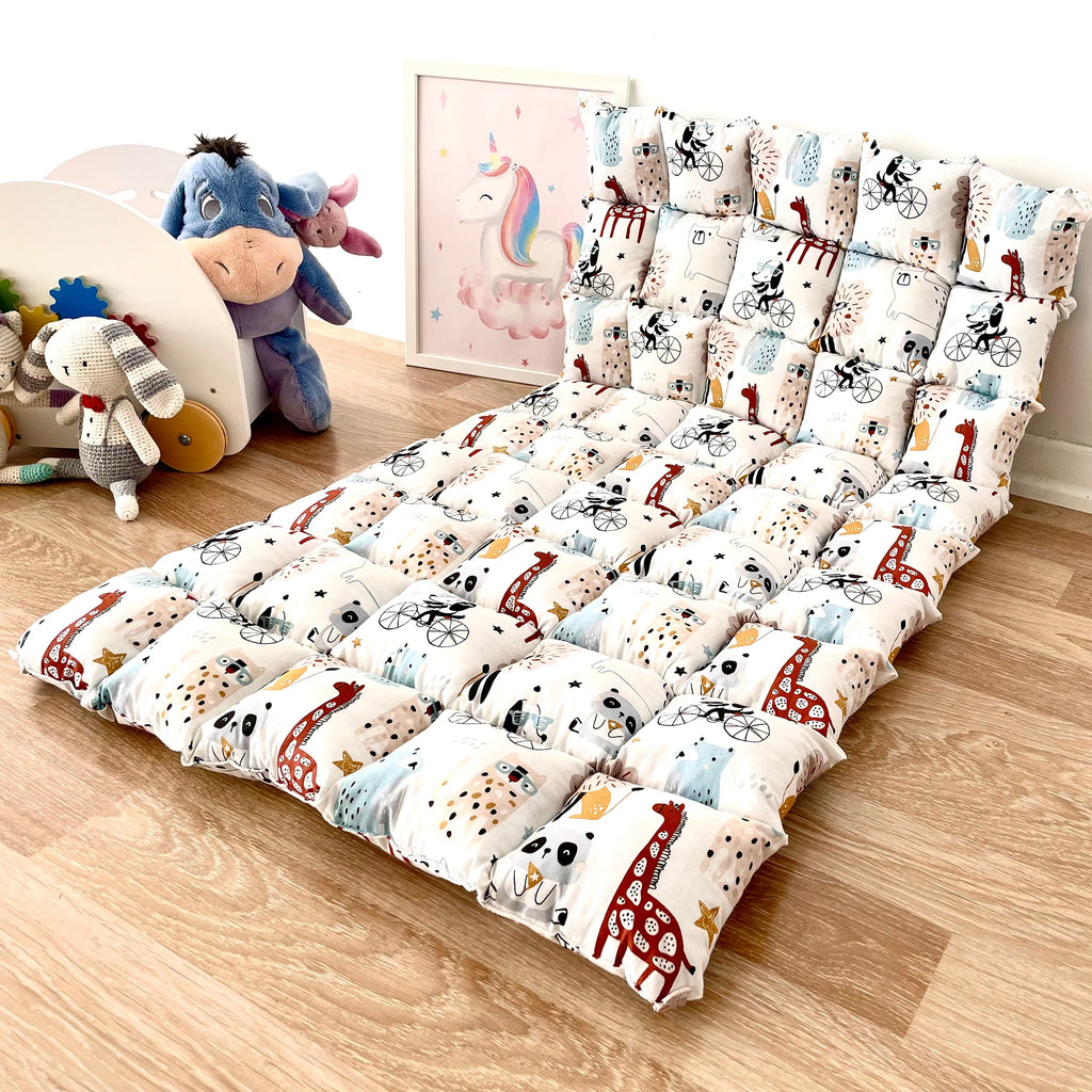 a child's bed with animals and giraffes on it