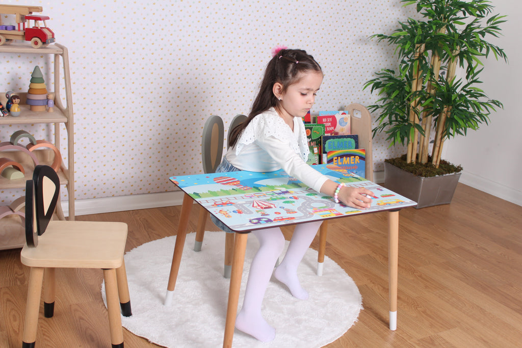 a little girl sitting at a table playing with a puzzle