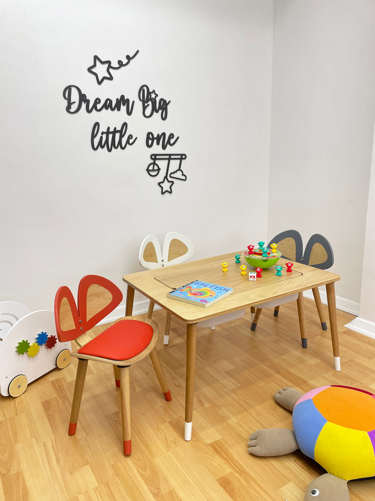 a child's playroom with a wooden table and chairs