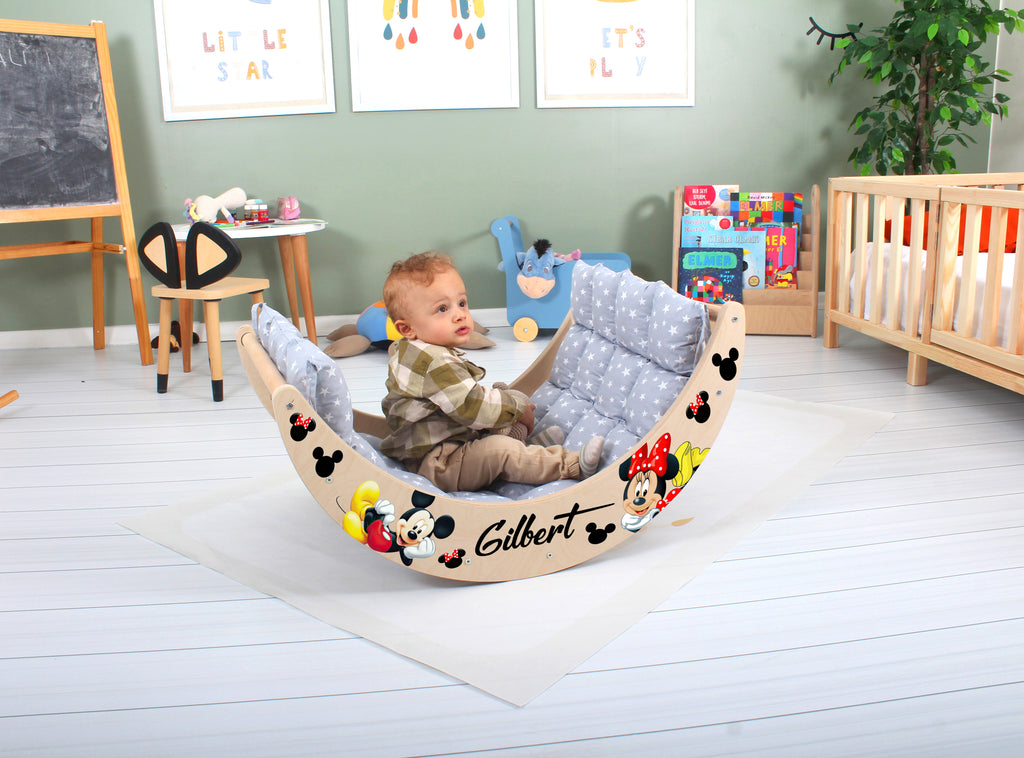 a baby sitting in a mickey mouse chair