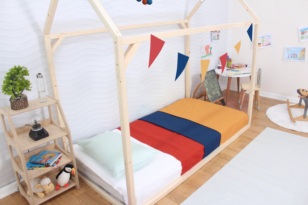 a child&#39;s bed with a wooden frame and colorful sheets